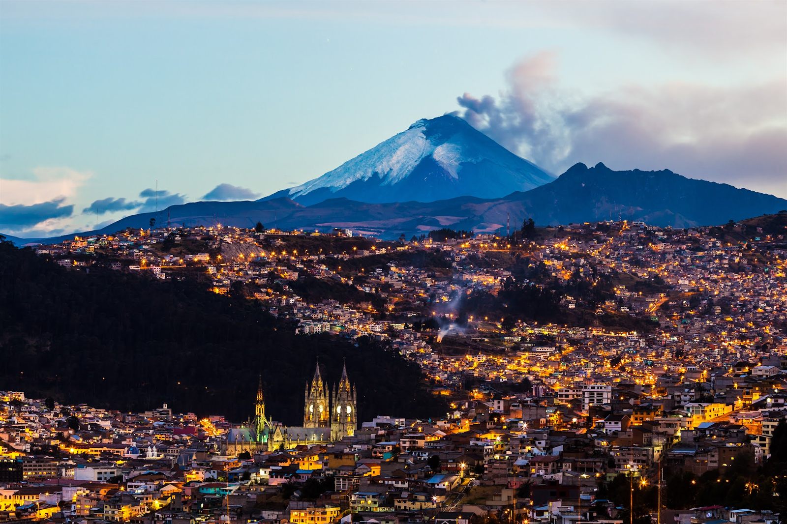 Quito al anochecer, con la Basílica del Voto Nacional y el Cotopaxi